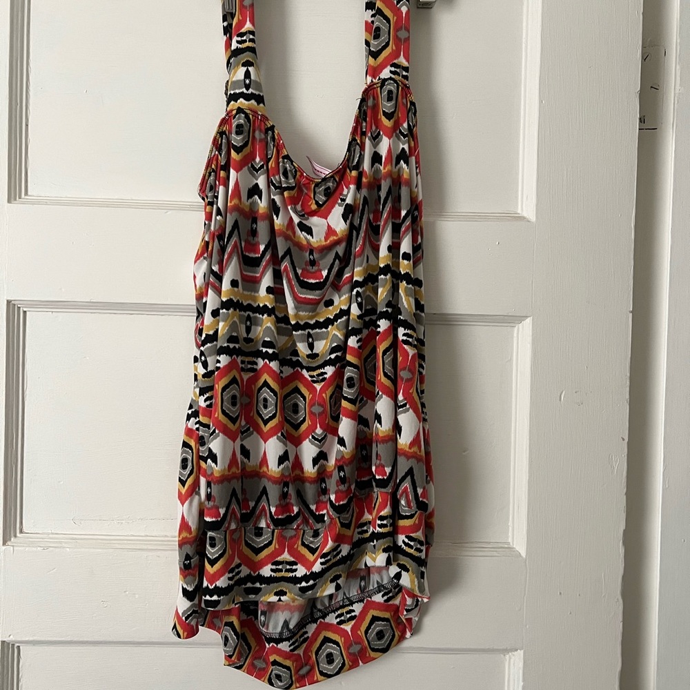 Flowing sleeveless blouse with beaded strap adornments.